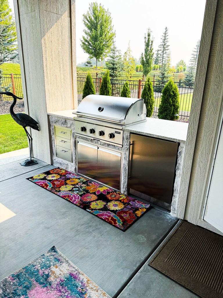 Custom outdoor kitchen with stone surround and built-in Coyote grill